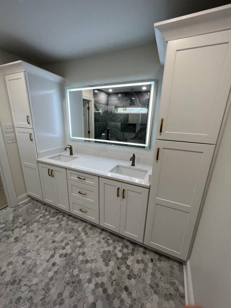 Elegant master bathroom with freestanding soaking tub, chandelier lighting, patterned tile flooring, and a frameless glass shower.