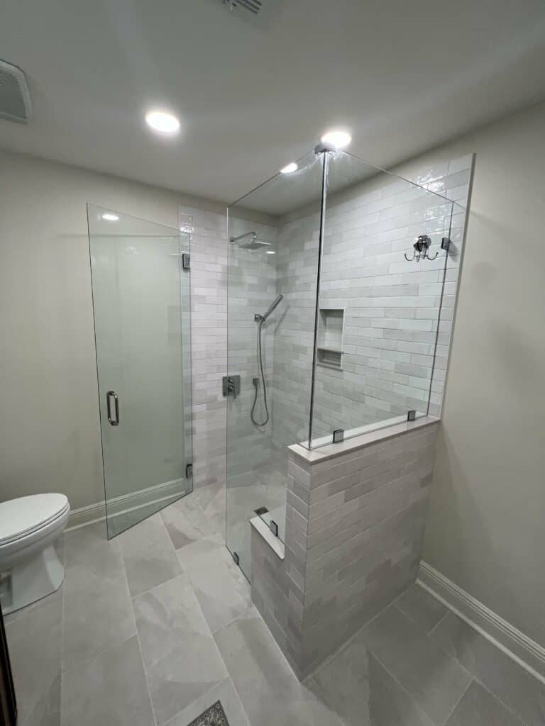 Curbless walk-in shower with glass enclosure and subway tile walls