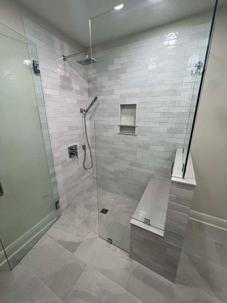 Curbless walk-in shower with white subway tile and built-in bench seating