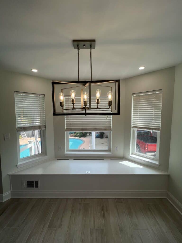 Custom kitchen remodel in Destrehan showcasing new cabinetry, quartzite countertops with seamless veining, and a built-in seating bench.